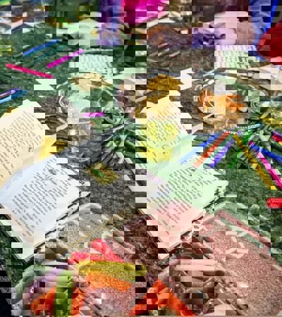 Foto af grøn dug med en bog og en tallerken med gifler og kiks. Eleverne spiser mens de læser.